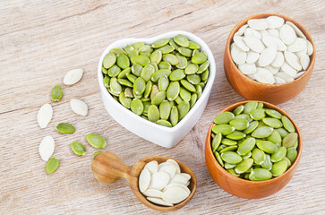 Pumpkin seeds green and unpeeled in wooden bowl.
