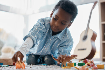 Give a boy a dinosaur and hell he entertained for ages. Shot of an adorable little boy playing with...