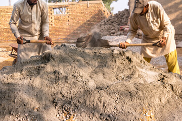 labor workers mixing cement and stone crush