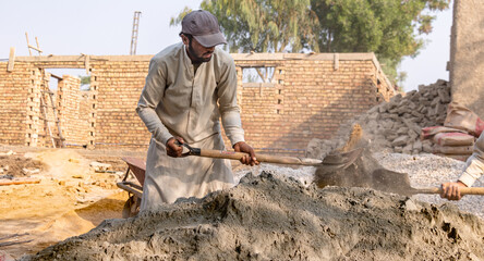 labor workers mixing cement and stone crush