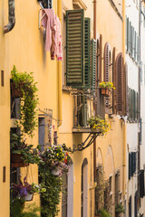 Fototapeta na wymiar facade of yellow apartment building in Florence, Italy with clothes drying outside 