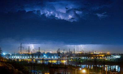 Spectacular industrial landscape with night thunderstorm, electric power lines and hydroelectric...