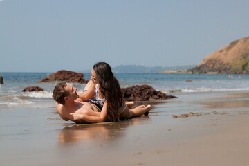 Young couple in love lying on the beach enjoying in Thailand.
