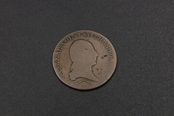 Old Austrian copper coin on black background