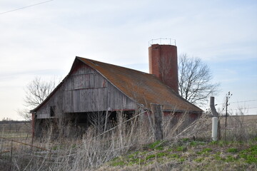 Weathered Barn and a Silo in a Farm Field