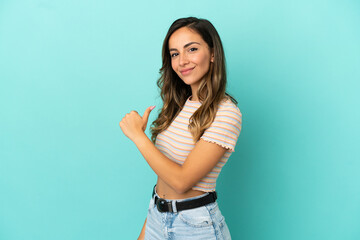 Young woman over isolated blue background proud and self-satisfied