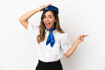Airplane stewardess over isolated white background surprised and pointing finger to the side