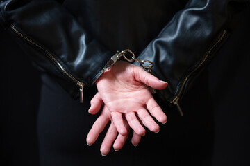 Arrest, protection from crime and law violation. Handcuff criminal woman hands close up.