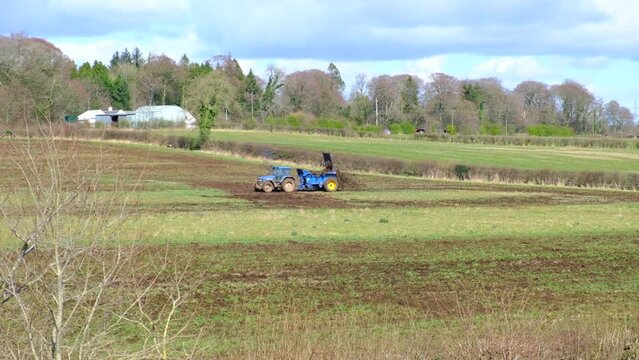 Tractor and Trailer loaded with Dung, Silage  Spreading it across the fields as part of the agricultural farming calendar. A seasonal agricultural image getting Scotlands farming industry moving.
