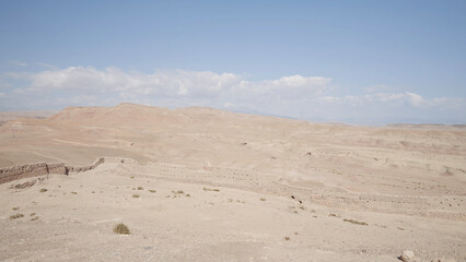 Fototapeta na wymiar Sandy desert on blue cloudy background. Action. Natural landscape with the endless desert.