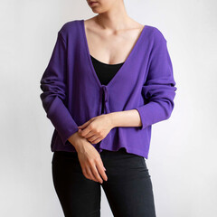 Young woman wearing purple cardigan and black trousers isolated on white background.