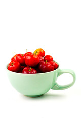 Acerola Cherry or Barbados Cherry in green cup isolated on white background.