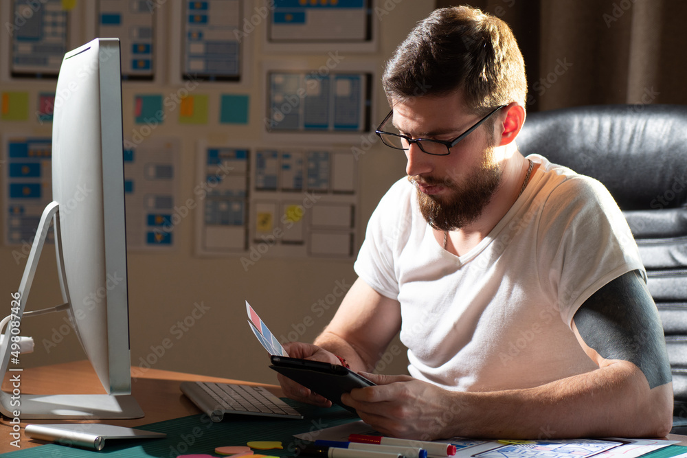 Poster mobile application design. male designer in workplace. graphic designer is sitting at computer. guy 