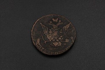 Old copper coin of Russian Empire on black background