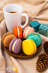 French pastries on a wooden bowl. A cup of tea. Macaroon composition.