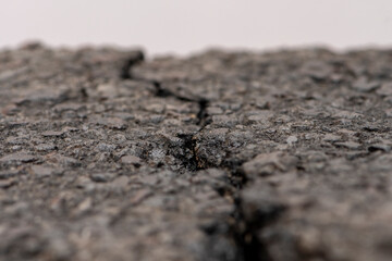 A crack in the asphalt, pits and destroyed pavement, a place for text, selective focus, close-up,...