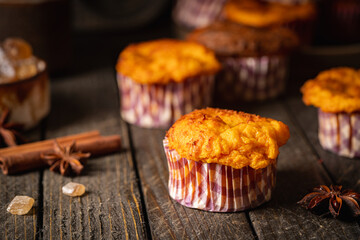 Sweet homemade cottage cheese muffins with pumpkin on dark wooden background