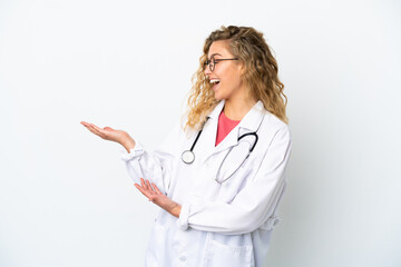 Young doctor blonde woman isolated on white background with surprise expression while looking side