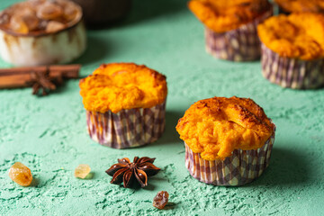 Sweet homemade cottage cheese muffins with pumpkin on blue background