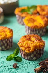 Sweet homemade cottage cheese muffins with pumpkin on blue background