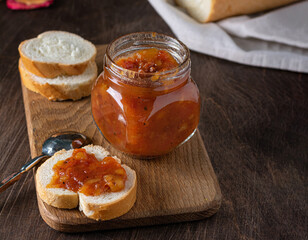 Homemade rmango chutney in glass jar on wooden background. Selective focus. Copy space