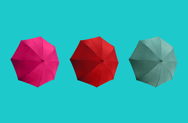 Top view, Set three colours umbrella isolated on cyan background, stock photo, invesment, business, summer concept, red pink dark cyan colors