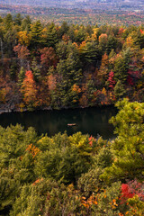 Obraz premium Small canoe on a peaceful lake, surrounded by colorful leaves and fall foliage. Mohonk Preserve, New York