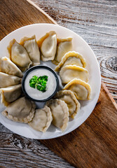 Composition with a plate of classic pierogies with sour cream