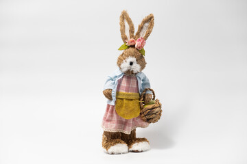 Easter Decorations Hare Rabbit of straw. Easter toy rabbit made of straw with a basket isolated on a white background