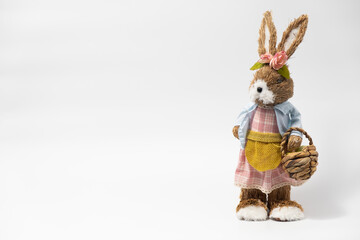 Easter Decorations Hare Rabbit of straw. Easter toy rabbit made of straw with a basket isolated on...