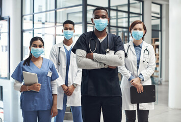 Its important to keep yourself protected. Shot of a group of doctors and nurses wearing face masks to protect from illness. - Powered by Adobe