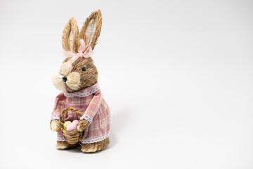 Easter Decorations Hare Rabbit of straw. Easter toy rabbit made of straw with a basket isolated on a white background