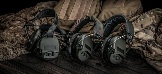 Protective headphones on a wooden surface. Safety equipment. Headphones for noise reduction. Dark...