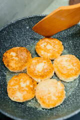 Frying cottage cheese pancake, fritter. Cottage cheese cakes frying ion hot pan. Cooking process