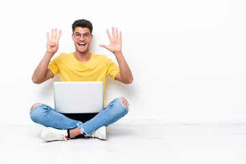 Young man sitting on the floor isolated on white background counting nine with fingers