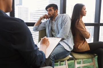 Professional Asian male psychiatrist giving advice to young couple having serious relationship...