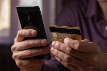 Man holding credit card making e bank online payment. Consumer paying for purchase using smartphone technology.