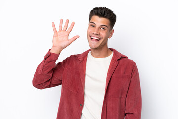 Young caucasian man isolated on white background saluting with hand with happy expression