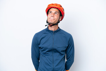 Young cyclist caucasian man isolated on white background and looking up
