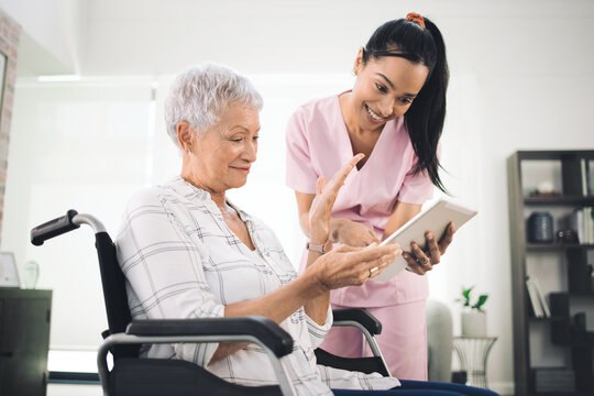 Dont Shrink To Fit In Child, Let Them Choke. Shot Of A Young Nurse Sharing Information From Her Digital Tablet With An Older Woman In A Wheelchair.