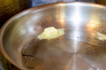 Cook heats butter in a steel frying pan