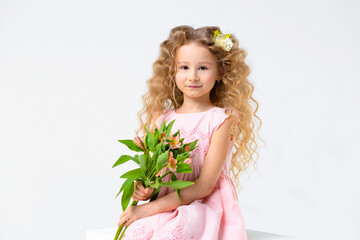 Obraz na płótnie Canvas little beautiful cute curls blonde girl with bouquet. Child with astromeria flowers in hands. spring holiday kid concept, international women's day, March 8, mother's day
