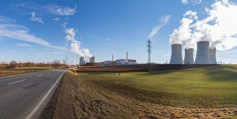 Fototapeta na wymiar Dukovany Nuclear Power Plant in the Czech Republic, Europe. Smoke cooling towers. There are clouds in the sky. In the background the nature of the Highlands.