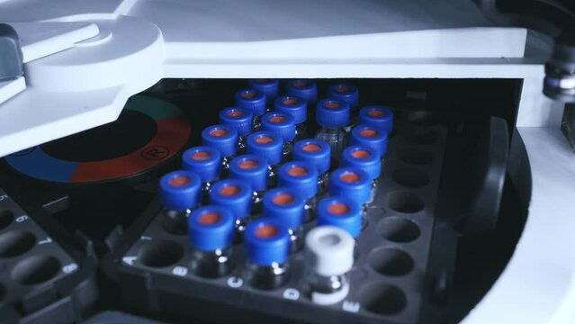 Glass vials in high-performance liquid chromatography autosampler at clinical lab. Separation of biological compounds. Scientific and research work extreme closeup