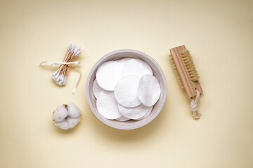 Spa concept. Cotton pads and cotton buds on a yellow background. Top view.