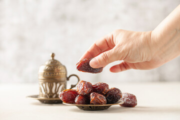 Cup of coffee and dry dates on saucer ready to eat for iftar time. Islamic religion and ramadan concept.