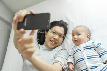 Mom and her son making video call with father and family, Happy Asian Young mother and her little...