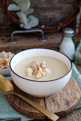 Cream soup with mushrooms and crackers.Wooden background, side view