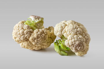 Two cauliflower heads on a light background