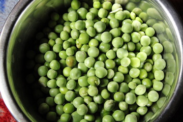 green peas ( Pisum sativum) in a bowl with green peas background.